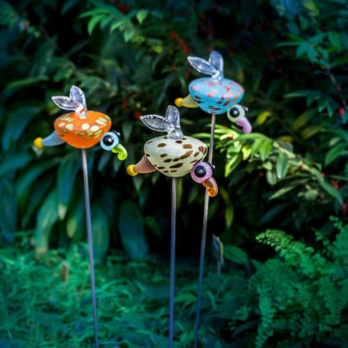 Das Glühwürmchen LUCY aus mundgeblasenem Glas dekoriert auf einem langen Metallstab Blumenbeete oder Gartenteiche.