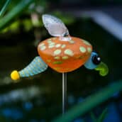 Das Glühwürmchen LUCY aus mundgeblasenem Glas dekoriert auf einem langen Metallstab Blumenbeete oder Gartenteiche.